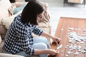 young-woman-doing-jigsaw-puzzle-home-young-woman-doing-jigsaw-puzzle-home-151327306